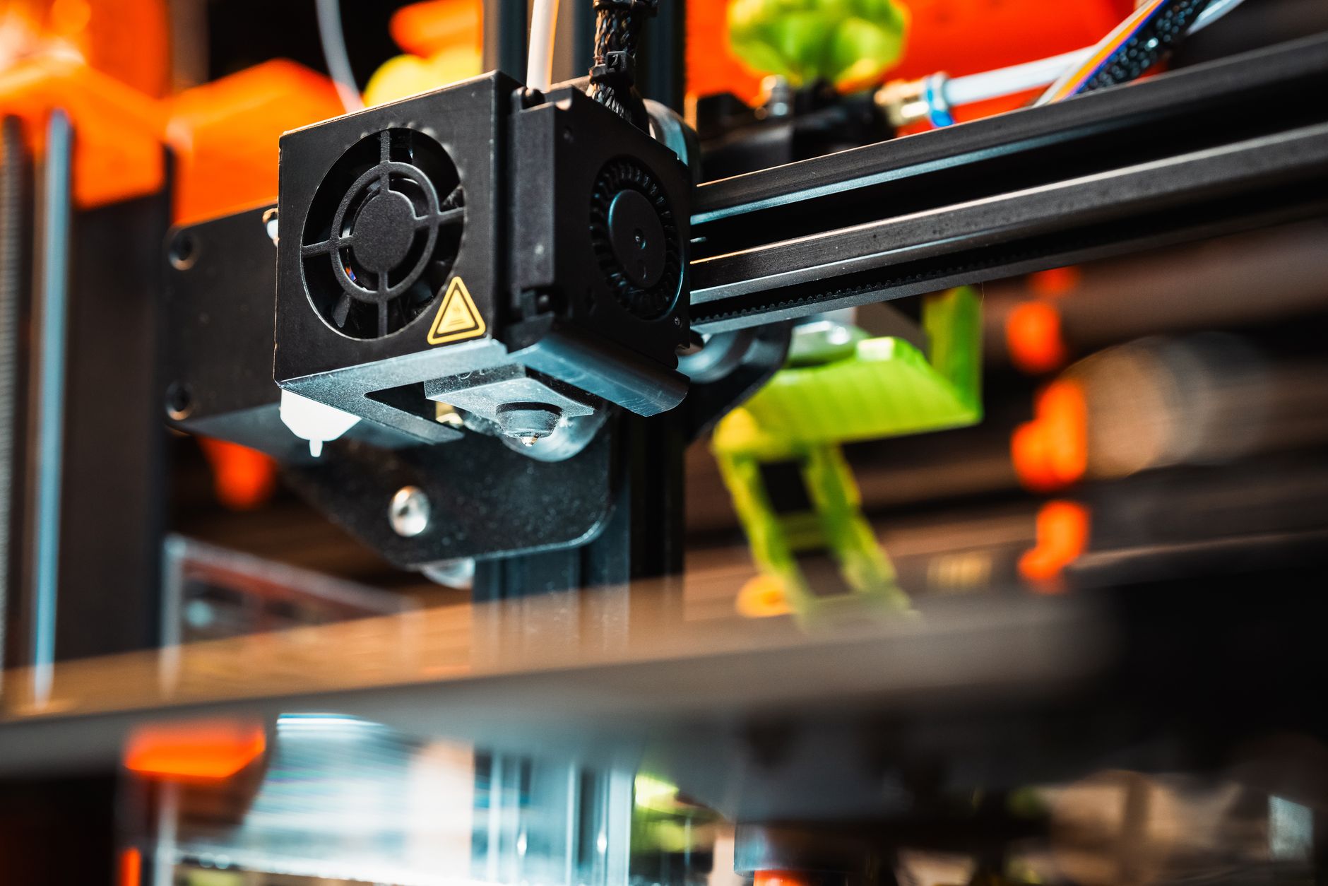 Detailed view of a 3D printer head during operation, showcasing modern printing technology.