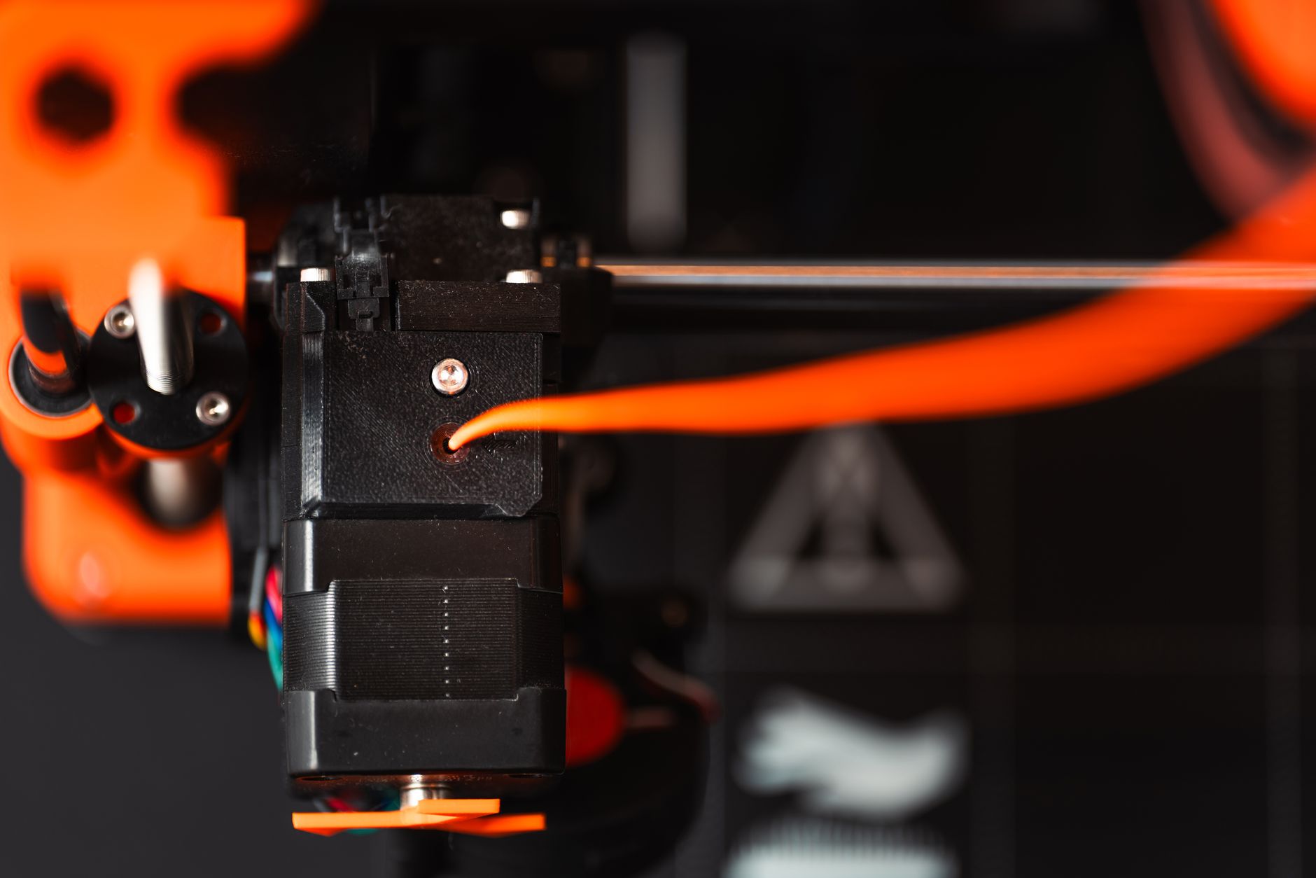 A focused girl with braided hair explores 3D printing using colorful filaments.