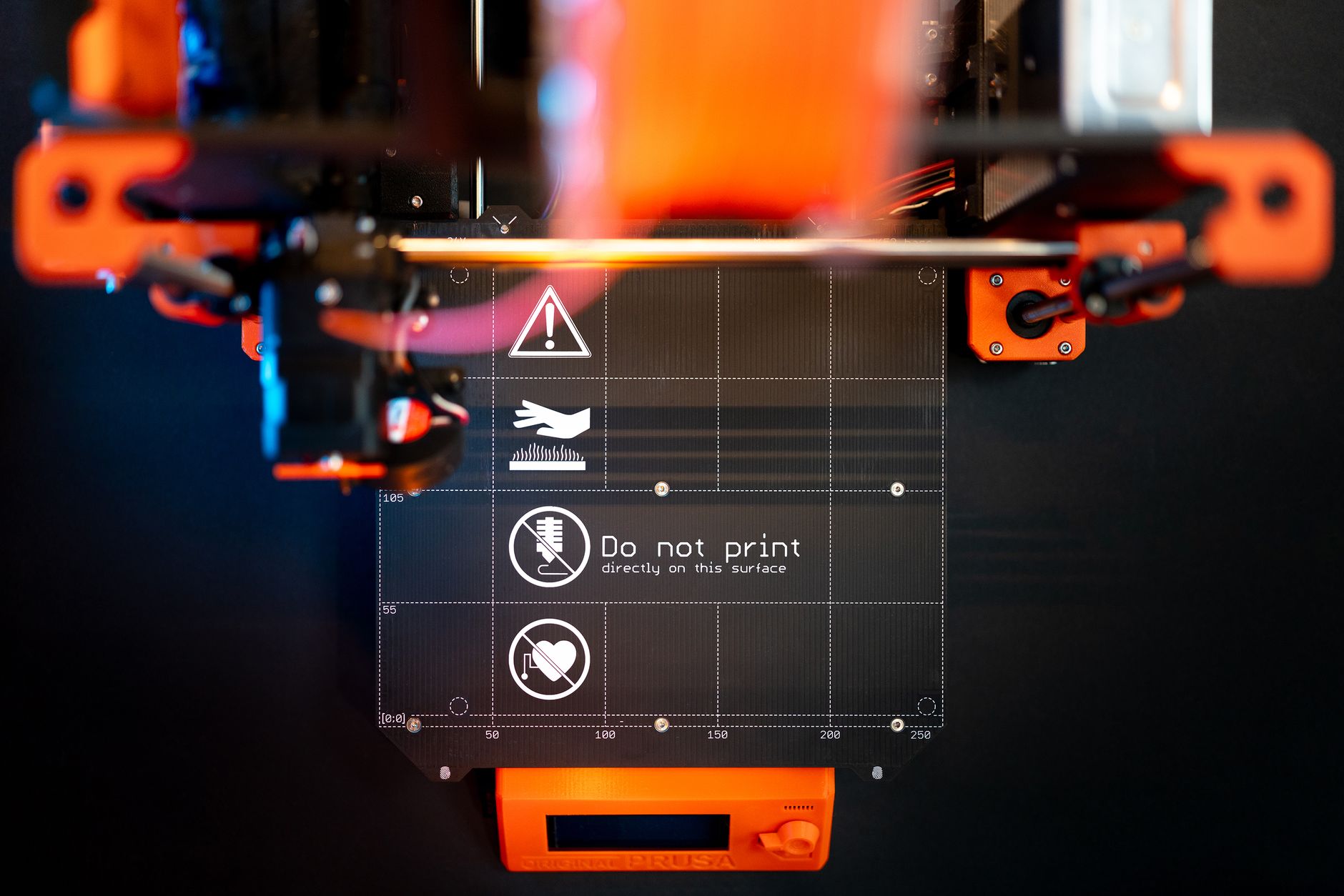 Close-up of blue 3D printed figurines on a printer bed, showcasing modern craftsmanship.