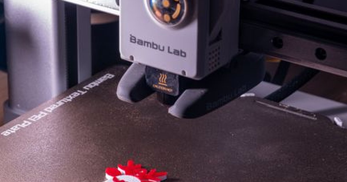 Close-up of a 3D printer creating vibrant snowman decorations, embodying modern technology and festive spirit.