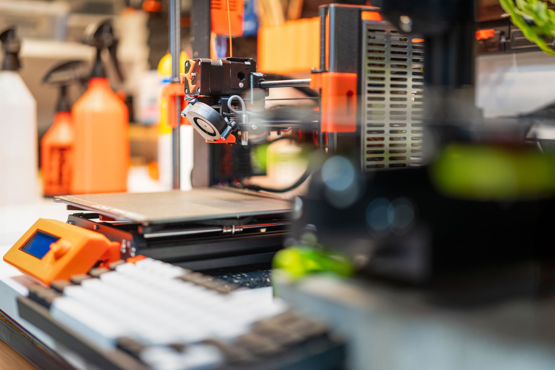 Close-up of a 3D printer creating a hexagonal object in a dimly lit workspace.
