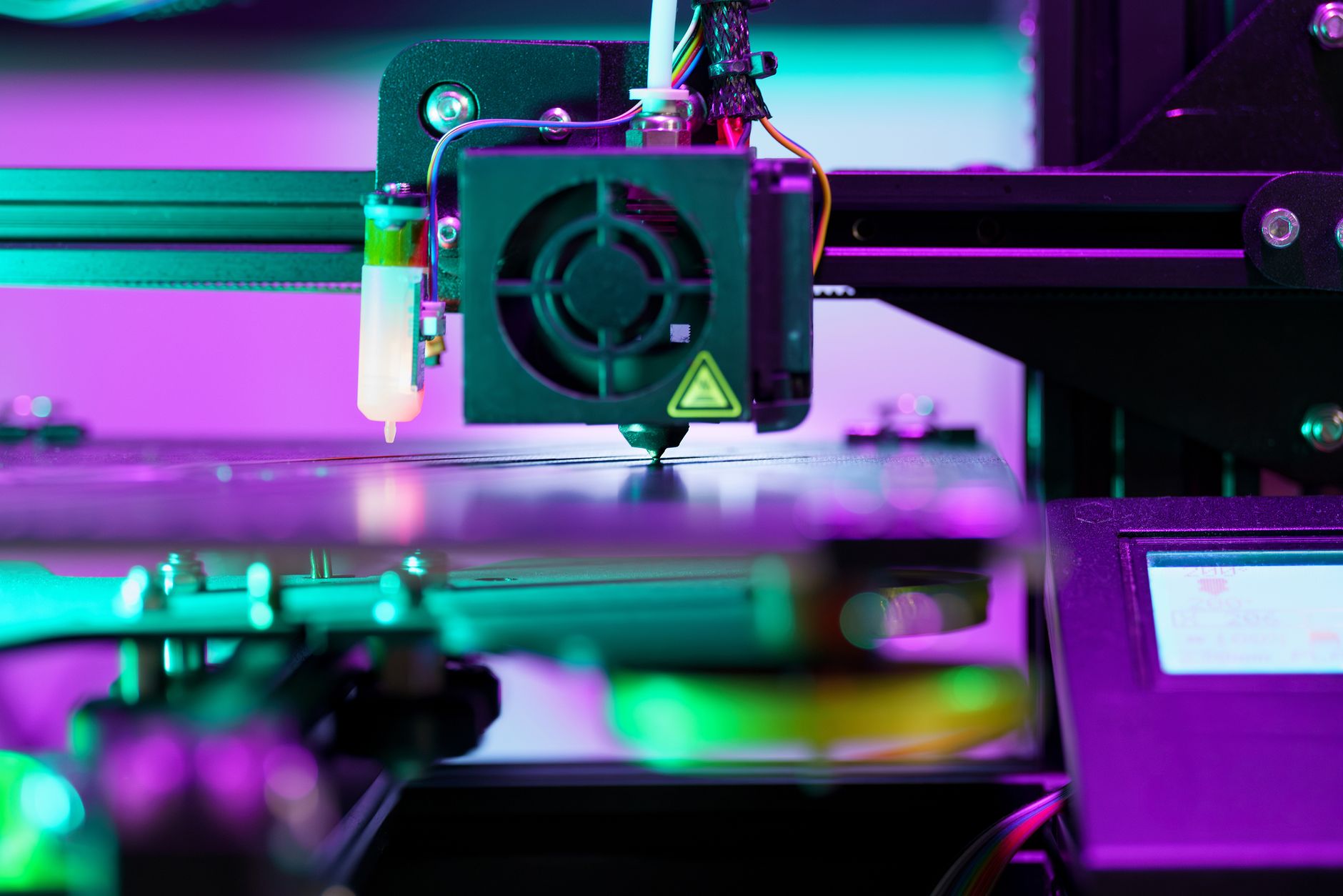Detailed view of a 3D printer actively working in a workshop environment, showcasing modern technology.