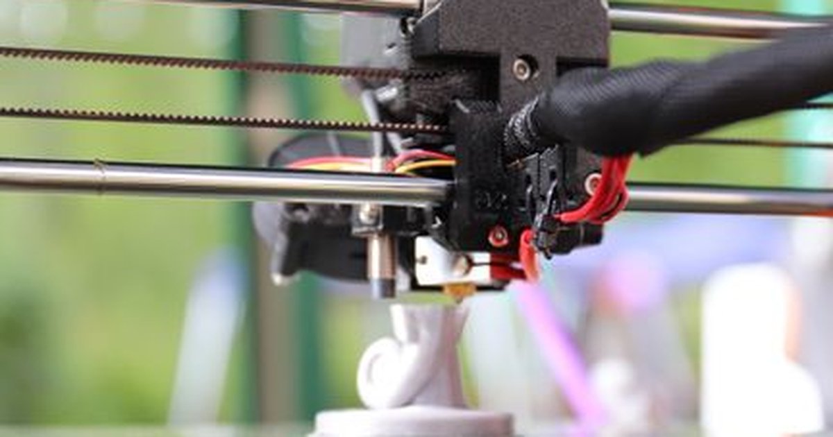 Detailed view of a 3D printer creating an object outdoors, highlighting innovation and precision.