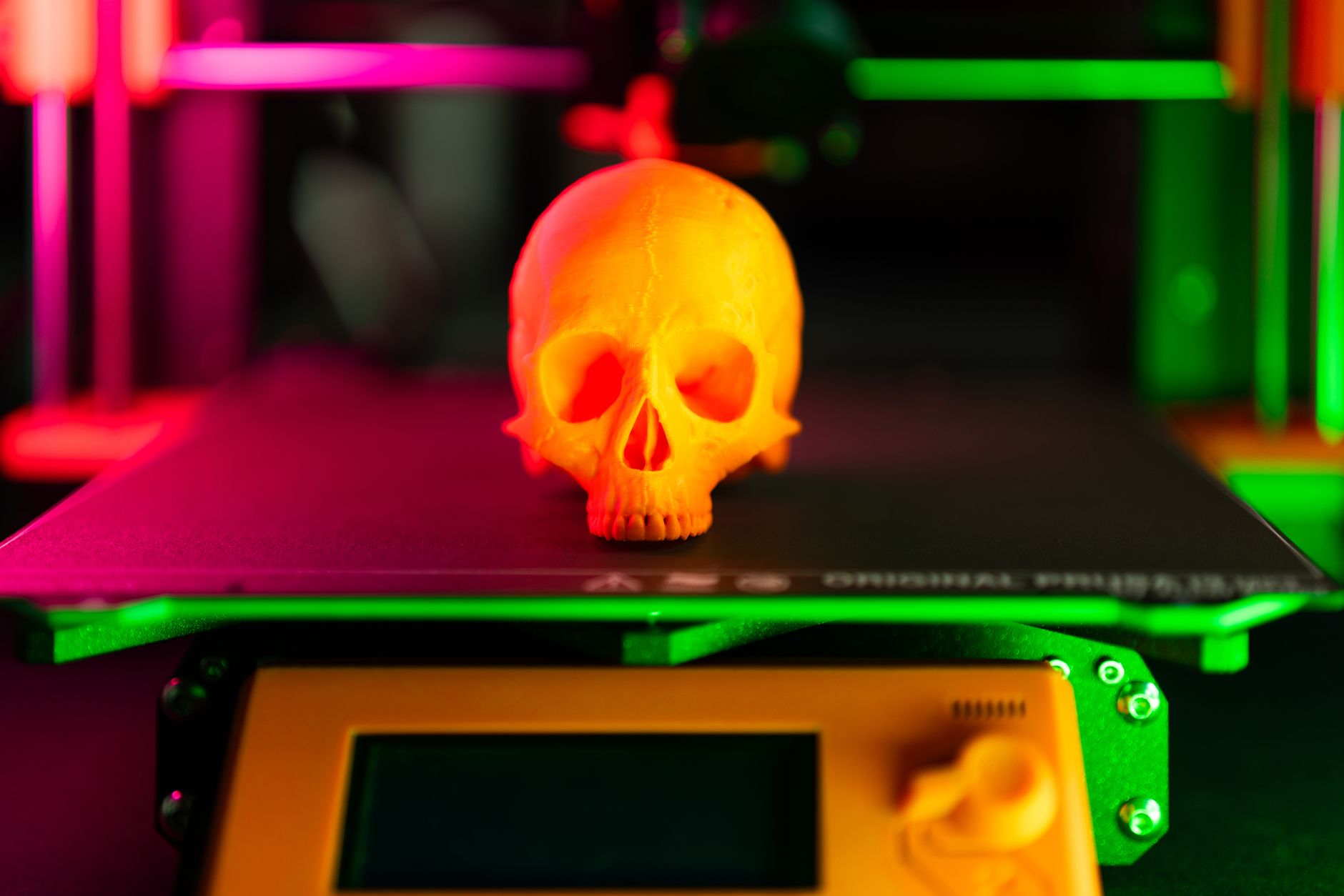 Close-up of a 3D printed part on an industrial printer in a workshop setting.